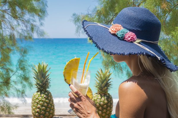 Woman drinking cocktail in the beach bar.